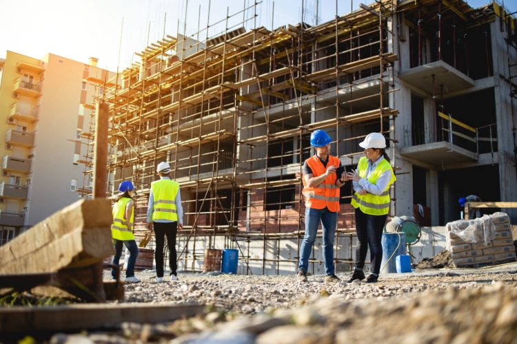 Vier Bauarbeiter und Bauarbeiterinnen auf einer Baustelle