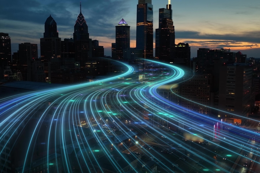 Futuristic digital highway concept over a city skyline at dusk, representing smart construction software accelerating infrastructure projects with advanced technology.