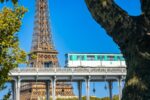 Paris Métro train crossing near the Eiffel Tower, showcasing historic infrastructure and urban transit innovation in the heart of Paris