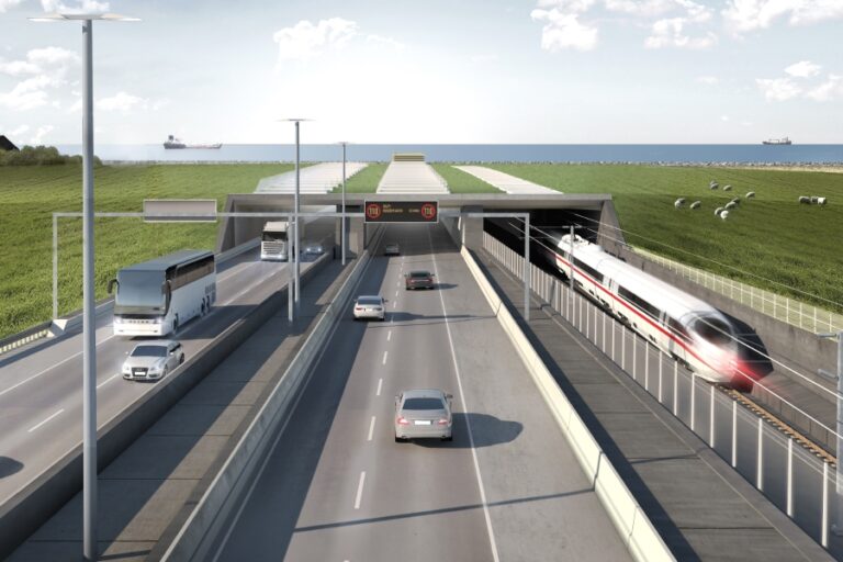 Construction crew guiding a massive concrete tunnel segment into a submerged trench using pontoons and cables