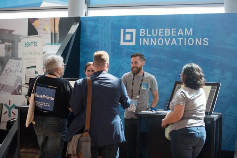 Construction pros collaborating over digital plans at a conference breakout session