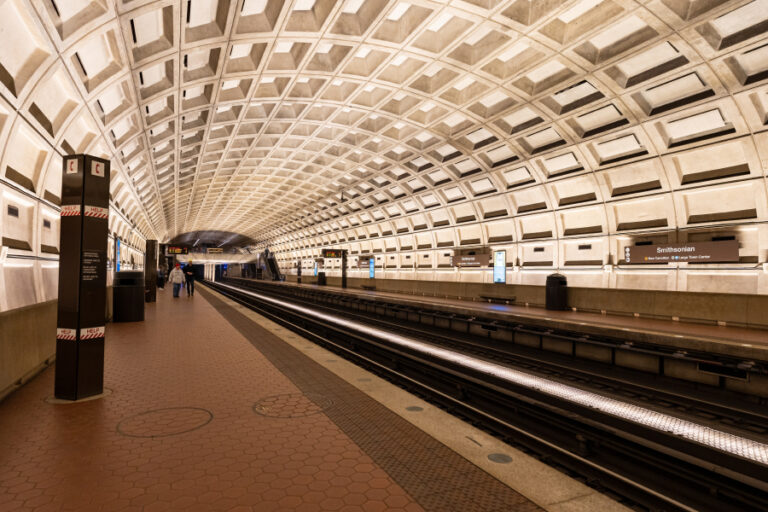 Smithsonian Metro station in Washington, D.C., with its iconic coffered concrete ceiling and glowing tunnel lights, symbolizing the hidden transit and stormwater infrastructure beneath the capital.