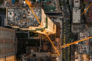 Aerial view of an active construction site with tower cranes and multi-building development, illustrating rising AEC technology investment amid ongoing workflow integration challenges.