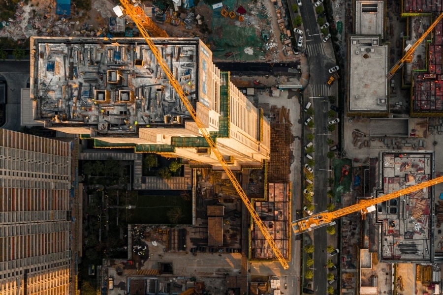 Aerial view of an active construction site with tower cranes and multi-building development, illustrating rising AEC technology investment amid ongoing workflow integration challenges.