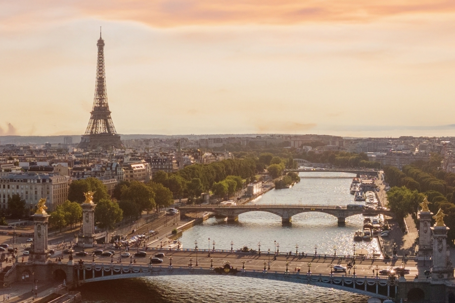 Panoramic view of Paris skyline with the Eiffel Tower and bridges over the Seine River, illustrating dense historic urban infrastructure where construction and renovation projects must adapt to tight space, heritage preservation and modern sustainability regulations.