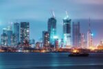 Mumbai skyline with high-rise towers and construction cranes at night, illustrating rapid urban development and infrastructure growth.
