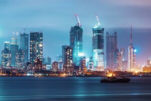 Mumbai skyline with high-rise towers and construction cranes at night, illustrating rapid urban development and infrastructure growth.