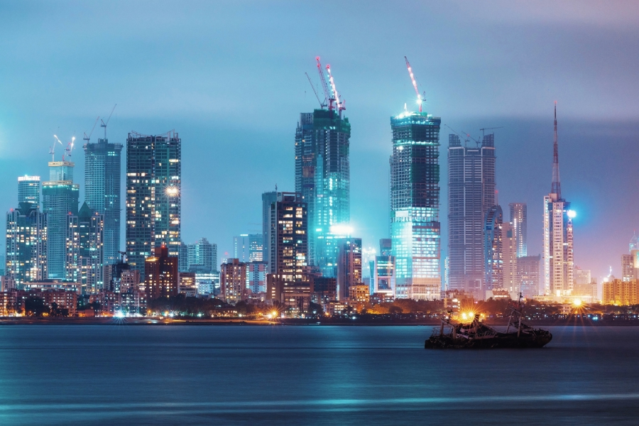 Mumbai skyline with high-rise towers and construction cranes at night, illustrating rapid urban development and infrastructure growth.