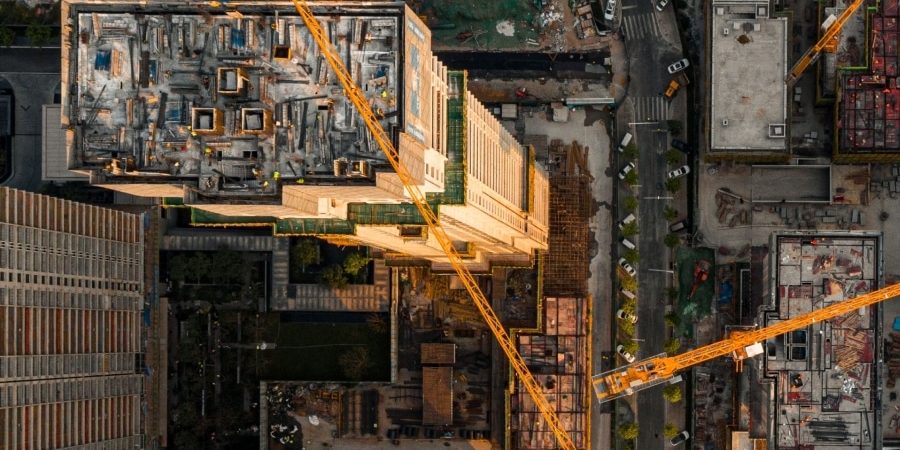 Aerial view of an active construction site with tower cranes and multi-building development, illustrating rising AEC technology investment amid ongoing workflow integration challenges.