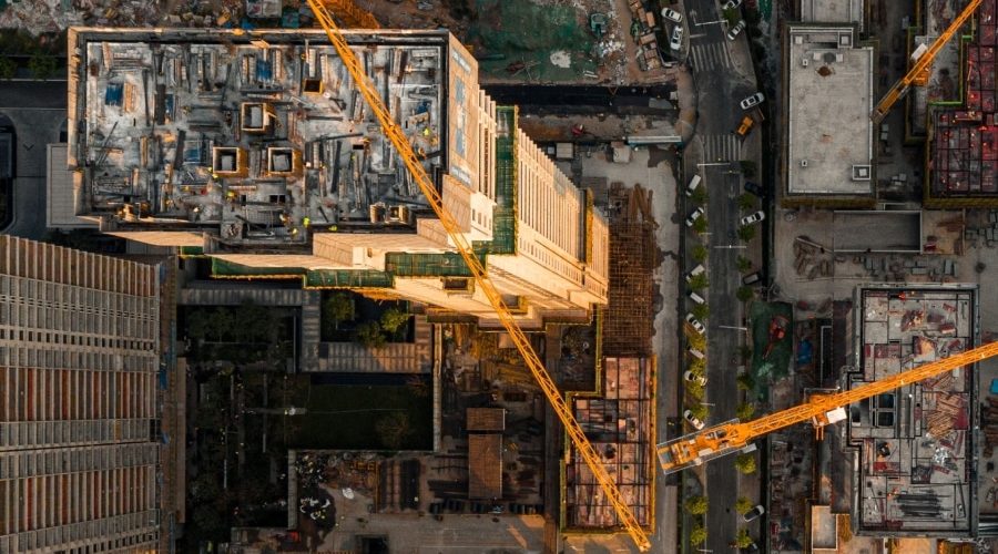 Aerial view of an active construction site with tower cranes and multi-building development, illustrating rising AEC technology investment amid ongoing workflow integration challenges.