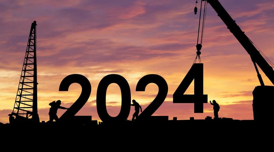 Construction site at sunset with cranes silhouetted against the sky, symbolizing progress and key industry milestones highlighted in Bluebeam's 'Top Built Stories of 2024' year-in-review blog article.