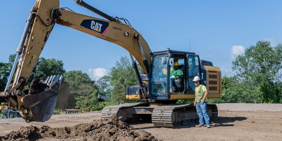 Excavator and construction worker on a job site in Pittsburgh, supporting PIT2Work's efforts to close the skilled labor gap in the construction industry.