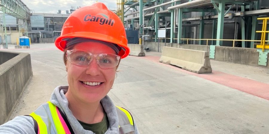 Mara Horn, construction manager at Cargill, smiles in a hard hat and safety gear while on-site at an industrial construction project, showcasing women’s leadership in the field.