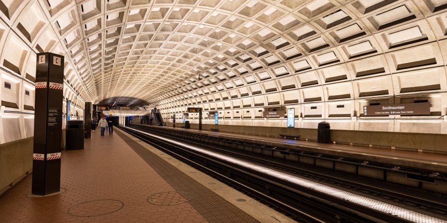 Smithsonian Metro station in Washington, D.C., with its iconic coffered concrete ceiling and glowing tunnel lights, symbolizing the hidden transit and stormwater infrastructure beneath the capital.