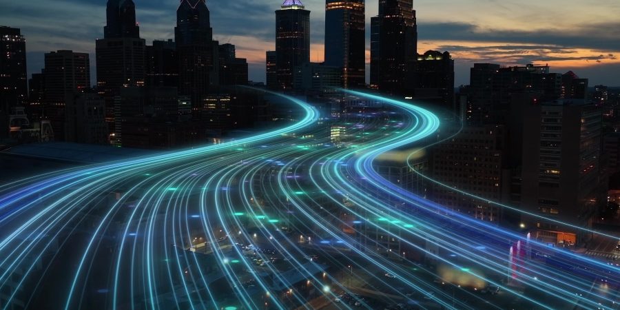 Futuristic digital highway concept over a city skyline at dusk, representing smart construction software accelerating infrastructure projects with advanced technology.