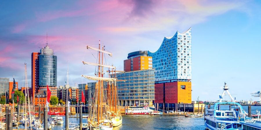 Modern harbor view in Hamburg, Germany featuring the iconic Elbphilharmonie concert hall and ships, symbolizing innovation and architecture—ideal for an article on Germany’s leadership in prefabricated construction.