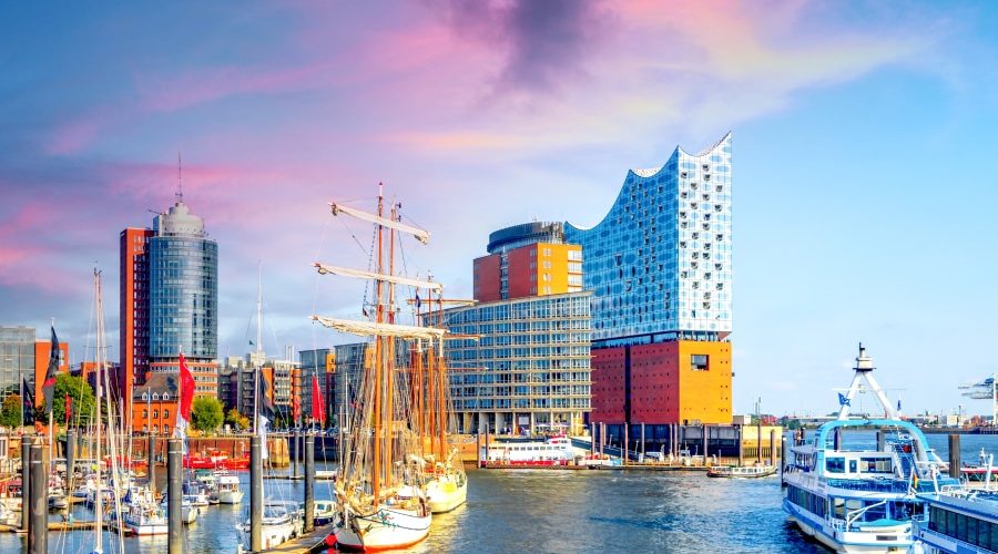 Modern harbor view in Hamburg, Germany featuring the iconic Elbphilharmonie concert hall and ships, symbolizing innovation and architecture—ideal for an article on Germany’s leadership in prefabricated construction.