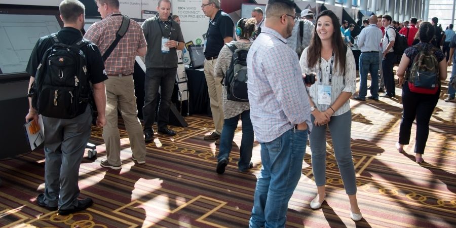 Construction professionals networking and exploring tech exhibits at a bustling industry conference—highlighting the dynamic energy of Bluebeam Unbound, happening in Washington, D.C., Sept. 30–Oct. 2, 2025. Register now to connect, learn, and lead the future of AEC.