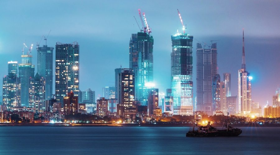 Mumbai skyline with high-rise towers and construction cranes at night, illustrating rapid urban development and infrastructure growth.