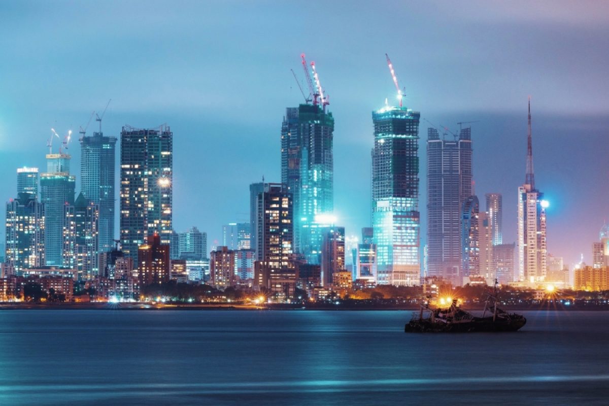 Mumbai skyline with high-rise towers and construction cranes at night, illustrating rapid urban development and infrastructure growth.