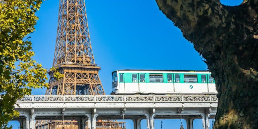 Paris Métro train crossing near the Eiffel Tower, showcasing historic infrastructure and urban transit innovation in the heart of Paris