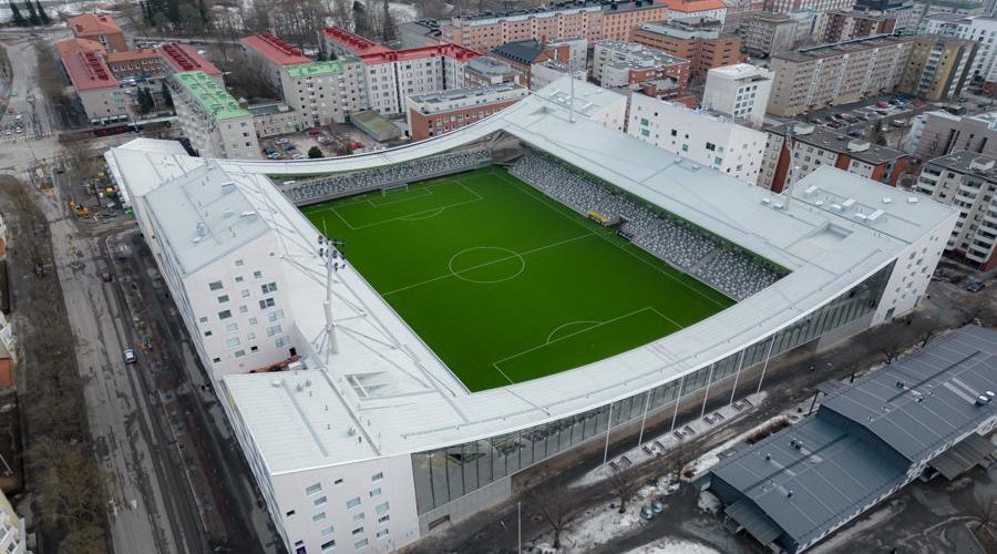 Aerial view of Finland’s Tammela Stadium in Tampere, a mixed-use urban design project by JKMM Architects that integrates a modern football pitch with residential apartments, retail spaces, and public amenities, showing how stadiums can revitalize neighborhoods instead of isolating them.